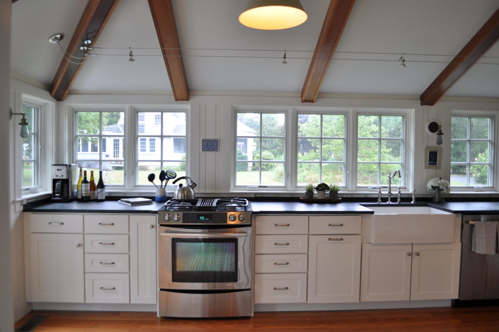 Immagine di una cucina chic con ante in stile shaker, ante bianche, top in saponaria, elettrodomestici in acciaio inossidabile e penisola