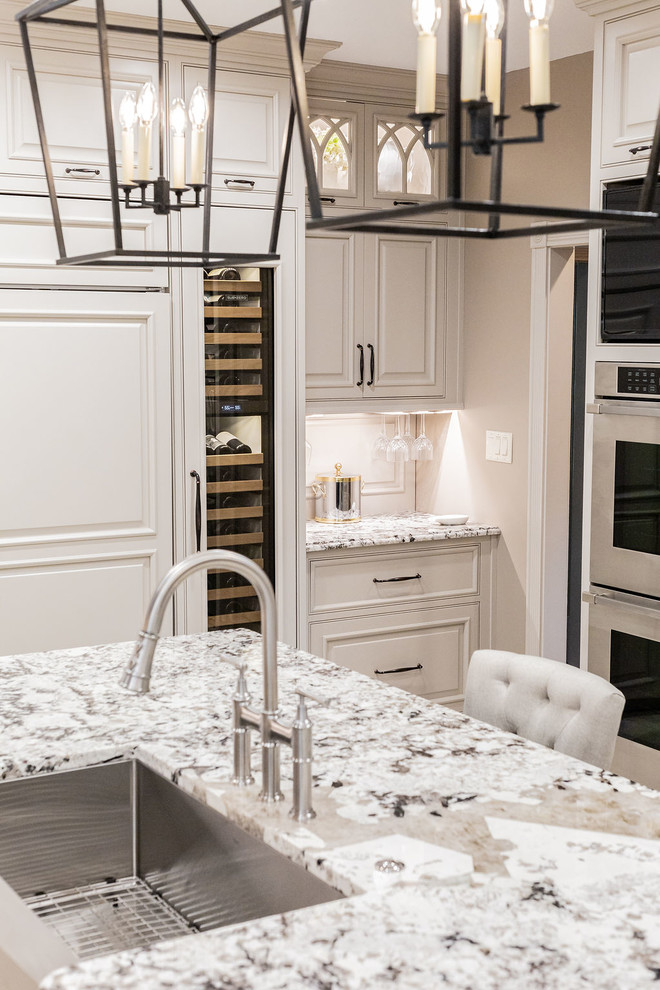 Example of a large transitional porcelain tile and beige floor kitchen design in Other with a farmhouse sink, beaded inset cabinets, gray cabinets, granite countertops, porcelain backsplash, stainless steel appliances, an island and beige countertops