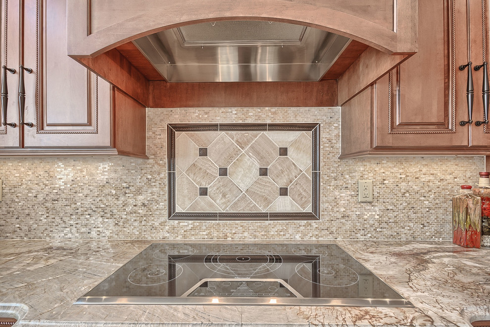 Photo of a large classic l-shaped kitchen/diner in St Louis with a submerged sink, raised-panel cabinets, medium wood cabinets, onyx worktops, beige splashback, stone tiled splashback, integrated appliances, porcelain flooring and an island.