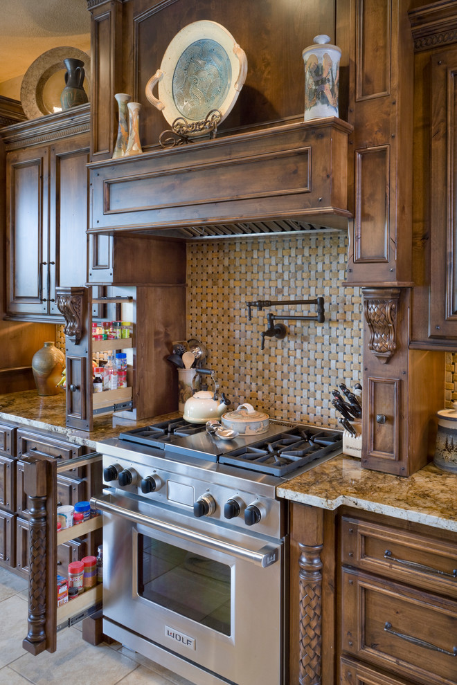 Aménagement d'une très grande cuisine parallèle classique en bois brun avec un plan de travail en granite, une crédence beige, une crédence en céramique, un électroménager en acier inoxydable et un sol en carrelage de céramique.