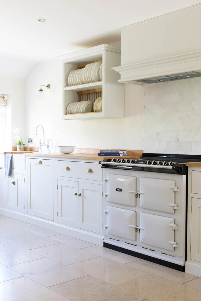 Immagine di una grande cucina abitabile classica con ante in stile shaker, ante bianche, pavimento in pietra calcarea, nessuna isola e pavimento beige