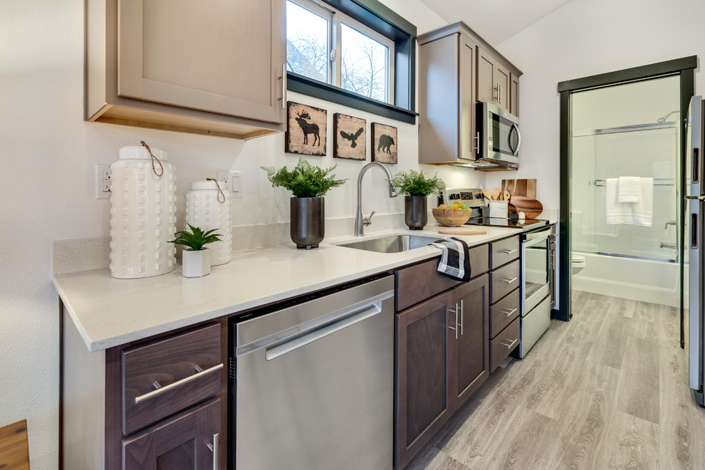 Small minimalist galley laminate floor and gray floor eat-in kitchen photo in Portland with a single-bowl sink, shaker cabinets, dark wood cabinets, quartz countertops, white backsplash, stone slab backsplash, stainless steel appliances, no island and white countertops