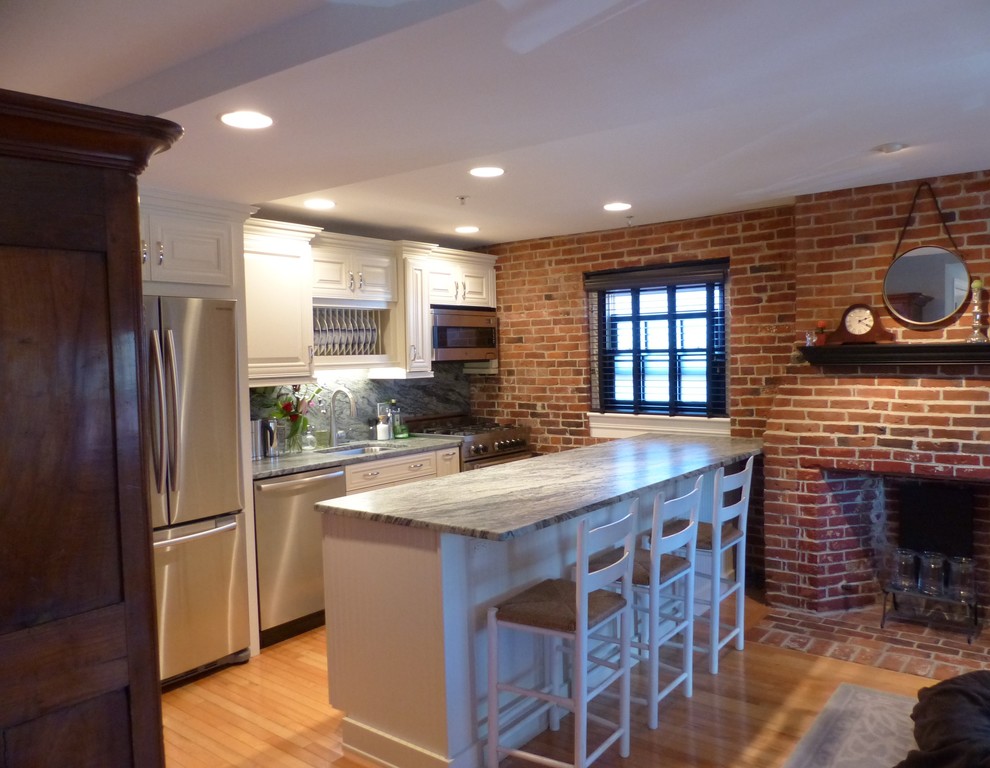 Idéer för små vintage kök, med en undermonterad diskho, luckor med upphöjd panel, vita skåp, granitbänkskiva, rosa stänkskydd, stänkskydd i sten, rostfria vitvaror, ljust trägolv, en köksö och gult golv