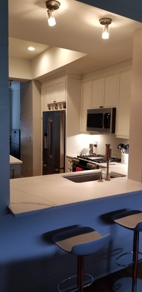 Example of a small minimalist galley eat-in kitchen design in Atlanta with white cabinets, stainless steel appliances, an island, white countertops, shaker cabinets, marble countertops, gray backsplash and wood backsplash