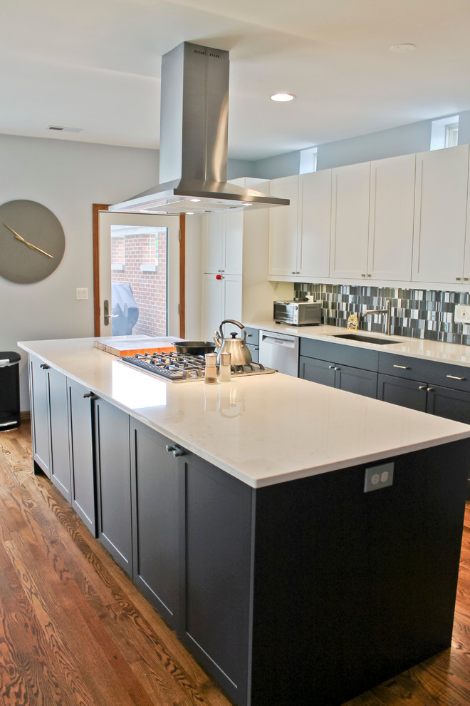 Idéer för mellanstora funkis kök och matrum, med en undermonterad diskho, luckor med infälld panel, grå skåp, marmorbänkskiva, stänkskydd med metallisk yta, stänkskydd i glaskakel, rostfria vitvaror, mellanmörkt trägolv och en köksö