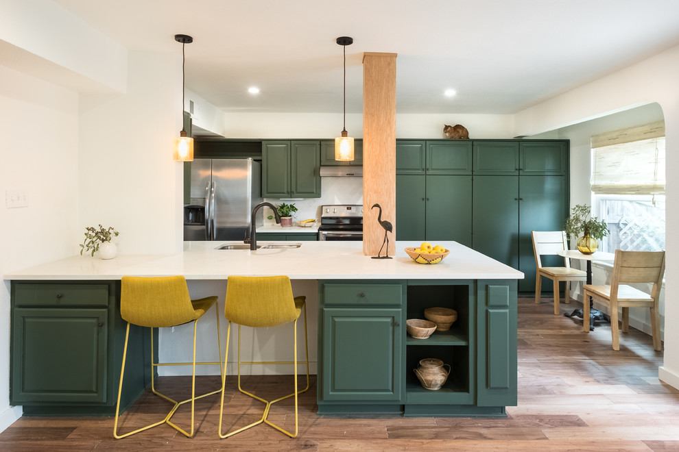 Inspiration for a medium sized classic kitchen/diner in Other with green cabinets, white splashback, limestone splashback, white worktops, a submerged sink, raised-panel cabinets, stainless steel appliances, medium hardwood flooring, a breakfast bar and brown floors.