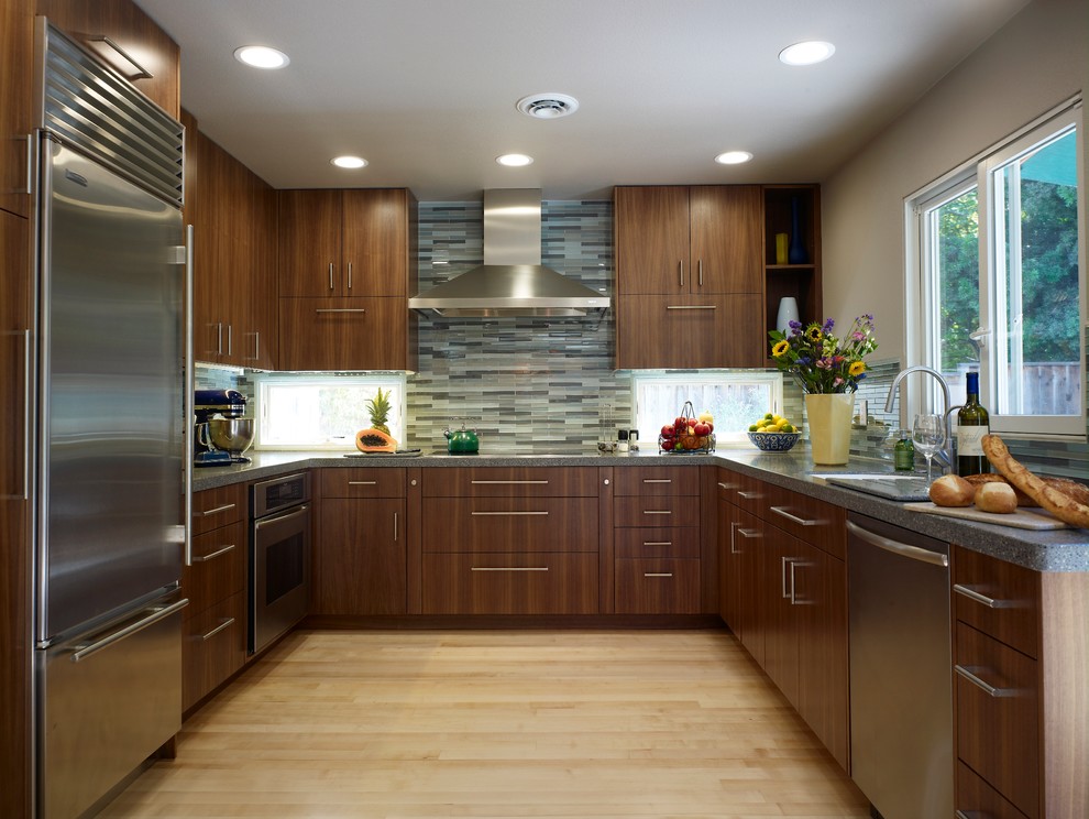 Exemple d'une cuisine tendance en U et bois foncé avec un placard à porte plane, une crédence multicolore, une crédence en mosaïque et un électroménager en acier inoxydable.