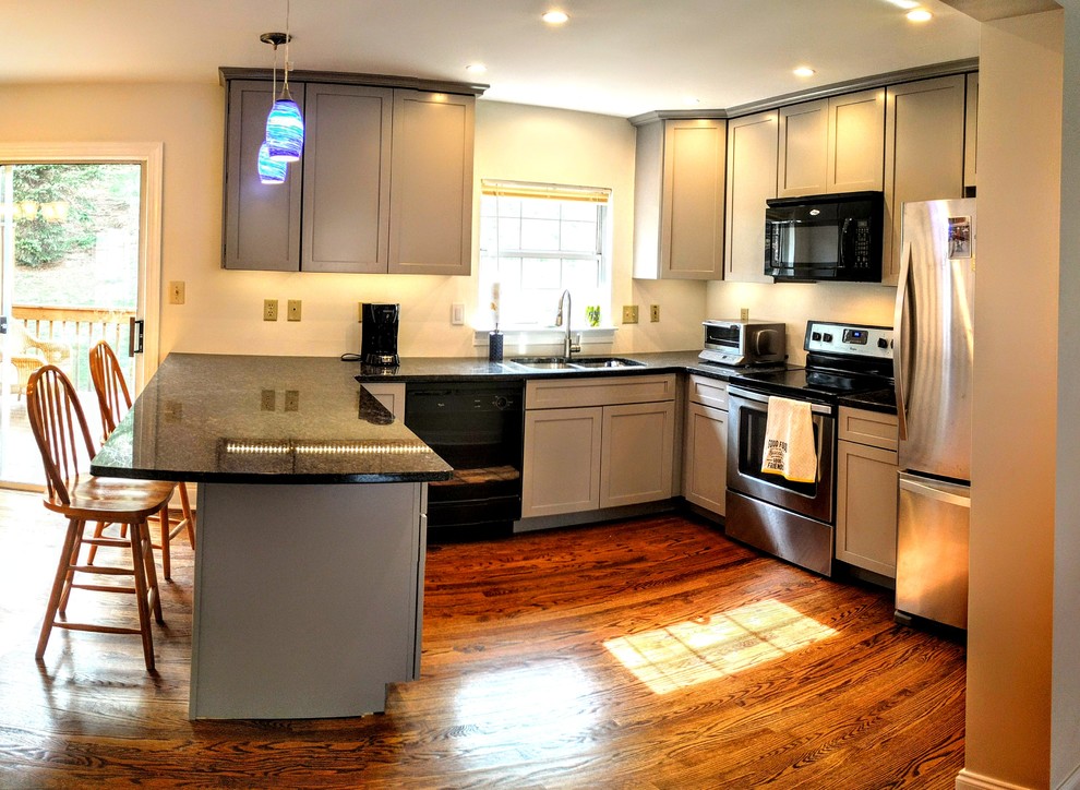 Mid-sized transitional u-shaped medium tone wood floor and brown floor eat-in kitchen photo in Baltimore with an undermount sink, shaker cabinets, gray cabinets, granite countertops, beige backsplash, stainless steel appliances and a peninsula