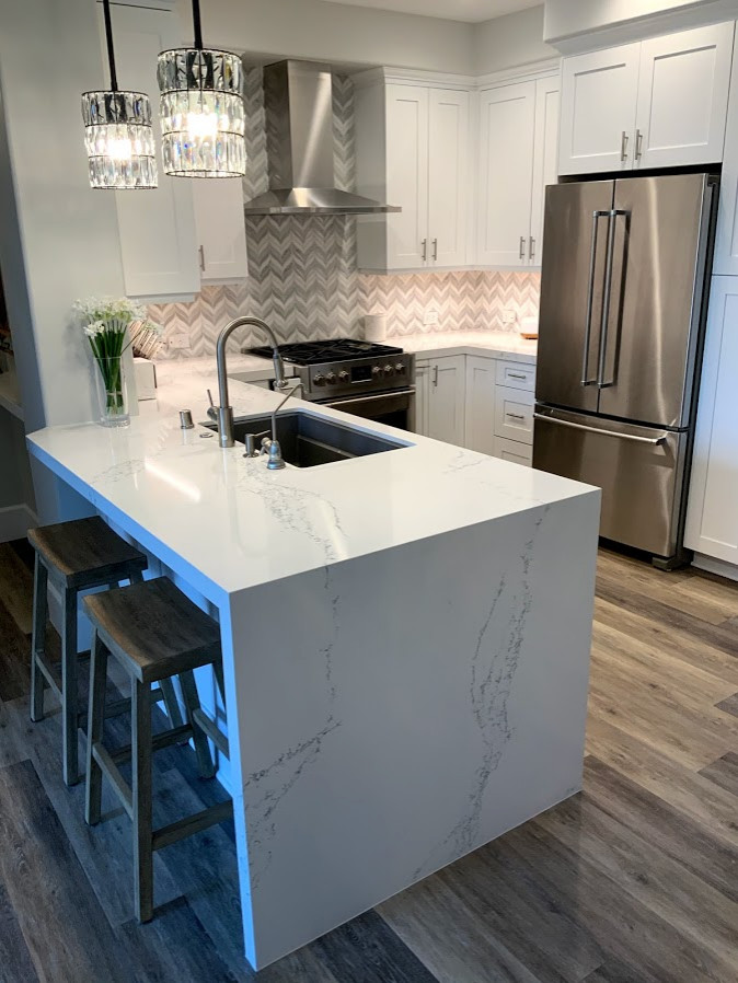 Eat-in kitchen - small modern u-shaped vinyl floor eat-in kitchen idea in Los Angeles with a single-bowl sink, recessed-panel cabinets, white cabinets, quartz countertops, mosaic tile backsplash, stainless steel appliances, a peninsula and white countertops
