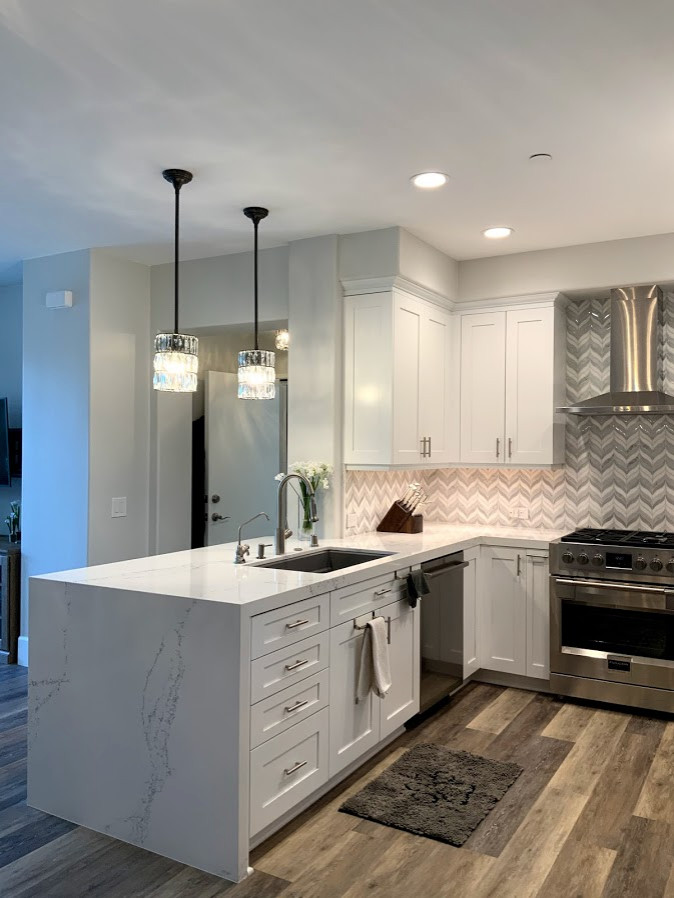 Small minimalist u-shaped vinyl floor eat-in kitchen photo in Los Angeles with a single-bowl sink, recessed-panel cabinets, white cabinets, quartz countertops, mosaic tile backsplash, stainless steel appliances, a peninsula and white countertops