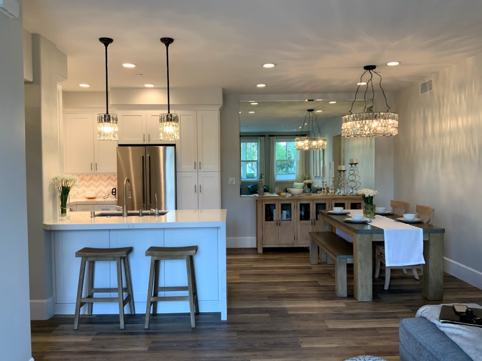 Example of a small minimalist u-shaped vinyl floor eat-in kitchen design in Los Angeles with a single-bowl sink, recessed-panel cabinets, white cabinets, quartz countertops, mosaic tile backsplash, stainless steel appliances, a peninsula and white countertops