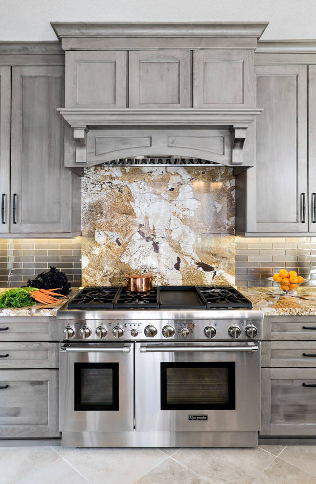 Immagine di una cucina classica di medie dimensioni con lavello sottopiano, ante in stile shaker, ante grigie, top in granito, paraspruzzi grigio, paraspruzzi con piastrelle di vetro, elettrodomestici in acciaio inossidabile e pavimento in gres porcellanato