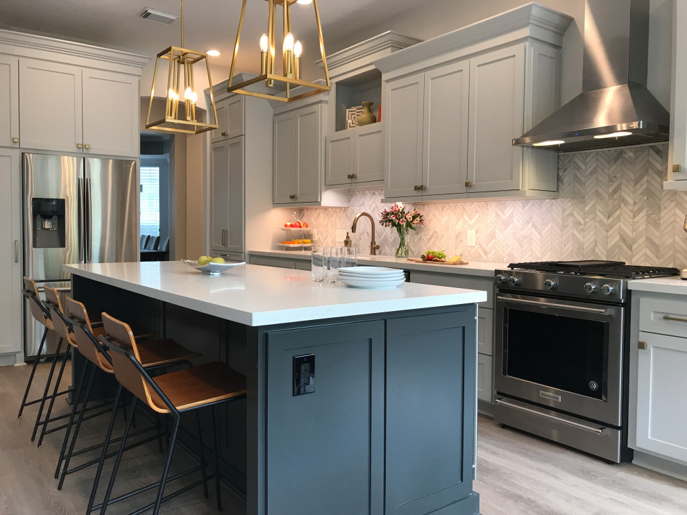 Inspiration for a mid-sized transitional l-shaped vinyl floor and beige floor eat-in kitchen remodel in Houston with shaker cabinets, gray cabinets, quartz countertops, white backsplash, marble backsplash, stainless steel appliances, an island, white countertops and an undermount sink