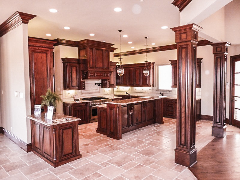 Example of a large classic u-shaped travertine floor eat-in kitchen design in Dallas with an undermount sink, raised-panel cabinets, dark wood cabinets, granite countertops, beige backsplash, ceramic backsplash, stainless steel appliances and an island