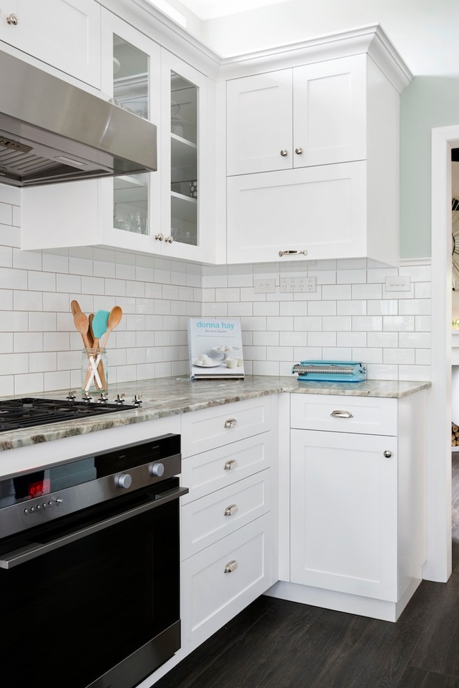 Bild på ett mellanstort vintage kök, med en rustik diskho, luckor med infälld panel, vita skåp, granitbänkskiva, vitt stänkskydd, stänkskydd i keramik, rostfria vitvaror, klinkergolv i porslin och en halv köksö