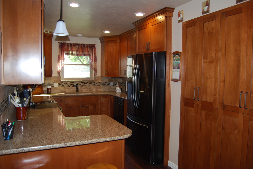 Example of a small classic u-shaped brown floor and vinyl floor enclosed kitchen design in Salt Lake City with shaker cabinets, red cabinets, granite countertops, multicolored backsplash, mosaic tile backsplash, black appliances, a peninsula and a double-bowl sink