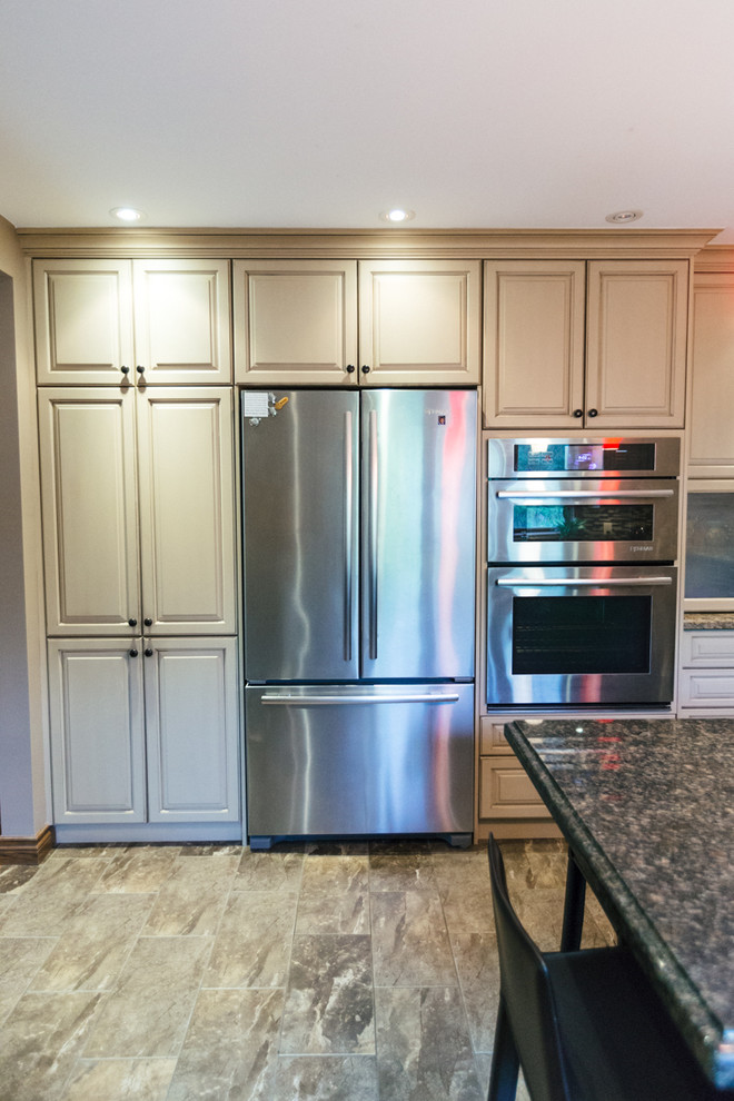 Foto på ett mellanstort funkis kök, med en rustik diskho, luckor med upphöjd panel, beige skåp, granitbänkskiva, flerfärgad stänkskydd, stänkskydd i stickkakel, rostfria vitvaror, travertin golv och en köksö