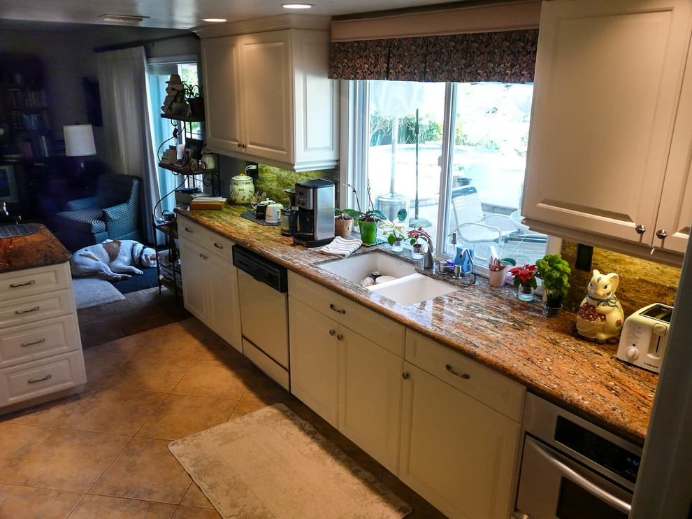 Inspiration for a medium sized traditional galley enclosed kitchen in San Diego with a submerged sink, raised-panel cabinets, white cabinets, granite worktops, stone slab splashback, stainless steel appliances and a breakfast bar.