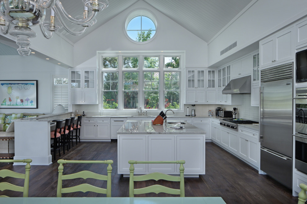 Klassisk inredning av ett kök, med luckor med infälld panel, vita skåp, vitt stänkskydd och rostfria vitvaror