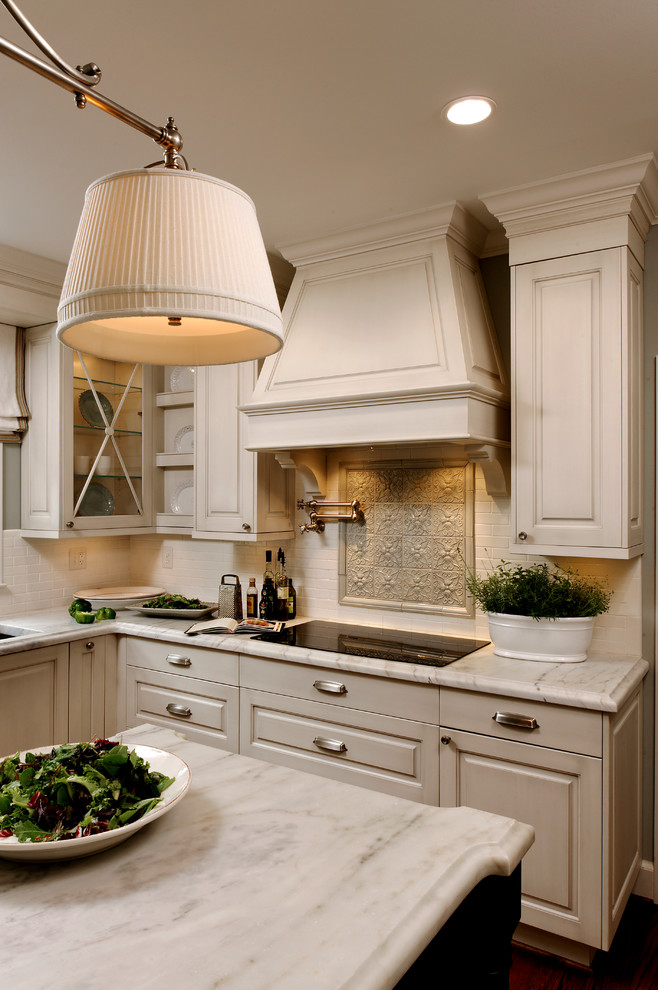 Klassisk inredning av ett mellanstort kök, med en undermonterad diskho, luckor med upphöjd panel, vita skåp, marmorbänkskiva, grått stänkskydd, stänkskydd i keramik, integrerade vitvaror, mellanmörkt trägolv och en köksö