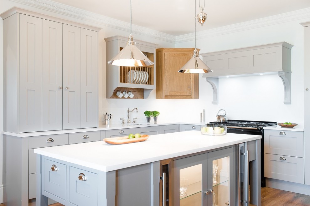 Mittelgroße Landhaus Küche in grau-weiß in L-Form mit Unterbauwaschbecken, Schrankfronten im Shaker-Stil, grauen Schränken, braunem Holzboden und Kücheninsel in Sonstige