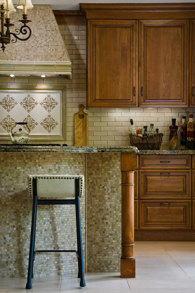 Exempel på ett mellanstort klassiskt linjärt kök med öppen planlösning, med en undermonterad diskho, luckor med upphöjd panel, skåp i mellenmörkt trä, granitbänkskiva, beige stänkskydd, stänkskydd i keramik, rostfria vitvaror, klinkergolv i porslin, en köksö och beiget golv