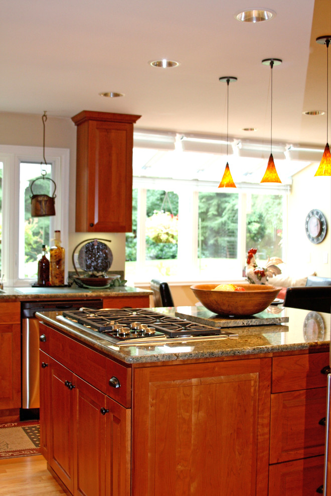 Inspiration for a mid-sized timeless l-shaped eat-in kitchen remodel in Seattle with an undermount sink, raised-panel cabinets, medium tone wood cabinets, granite countertops, multicolored backsplash, stone slab backsplash, stainless steel appliances and an island