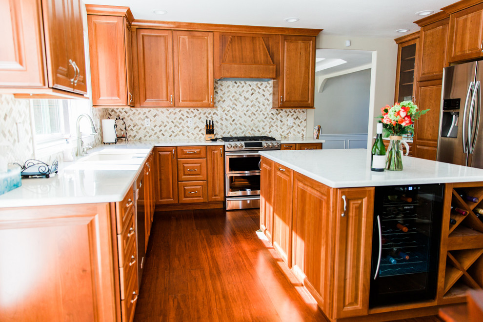This is an example of a large classic u-shaped open plan kitchen in Seattle with a submerged sink, raised-panel cabinets, medium wood cabinets, engineered stone countertops, multi-coloured splashback, mosaic tiled splashback, stainless steel appliances, bamboo flooring, an island and brown floors.