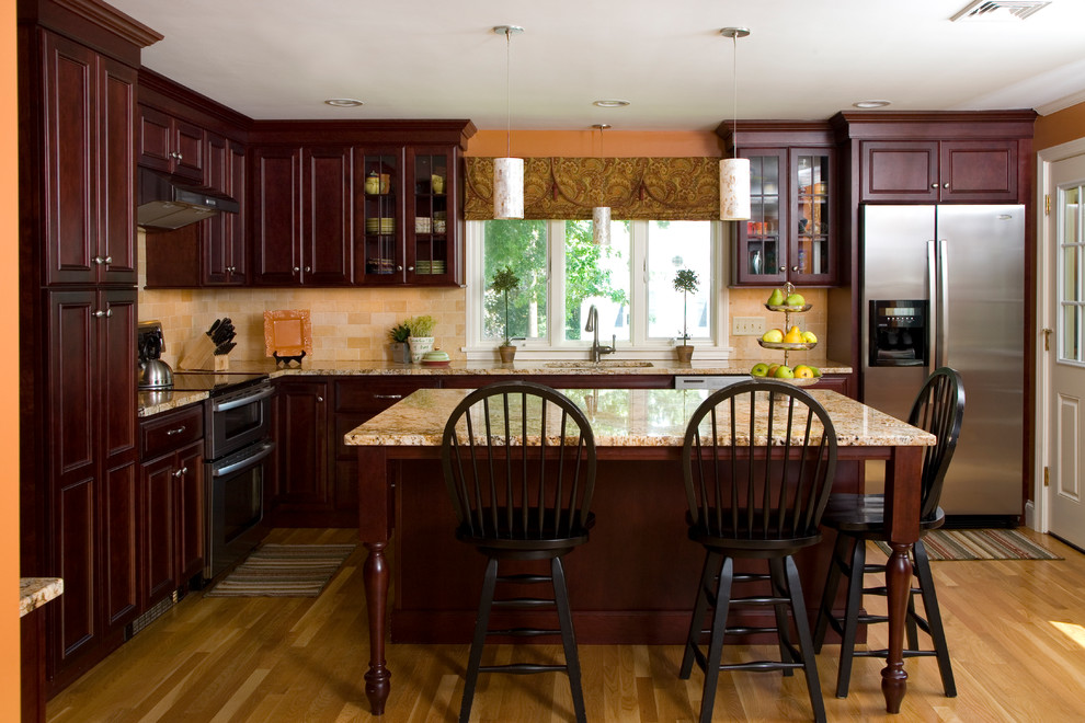 This is an example of a traditional kitchen in Boston with stainless steel appliances and travertine splashback.