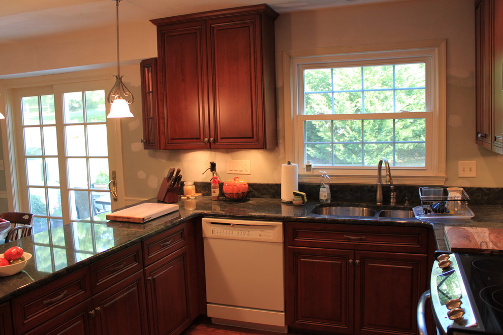 Inspiration for a traditional u-shaped kitchen in Baltimore with a double-bowl sink, raised-panel cabinets, medium wood cabinets, granite worktops, beige splashback, white appliances, medium hardwood flooring and a breakfast bar.
