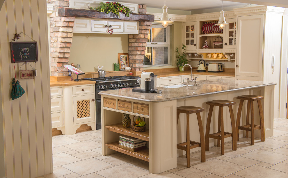 Foto på ett lantligt l-kök, med en rustik diskho, luckor med infälld panel, granitbänkskiva, svarta vitvaror, en köksö, beiget golv och beige skåp
