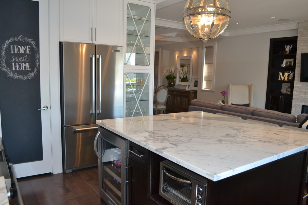 Kitchen pantry - large traditional u-shaped medium tone wood floor kitchen pantry idea in Vancouver with an undermount sink, shaker cabinets, white cabinets, marble countertops, white backsplash, porcelain backsplash, stainless steel appliances and an island