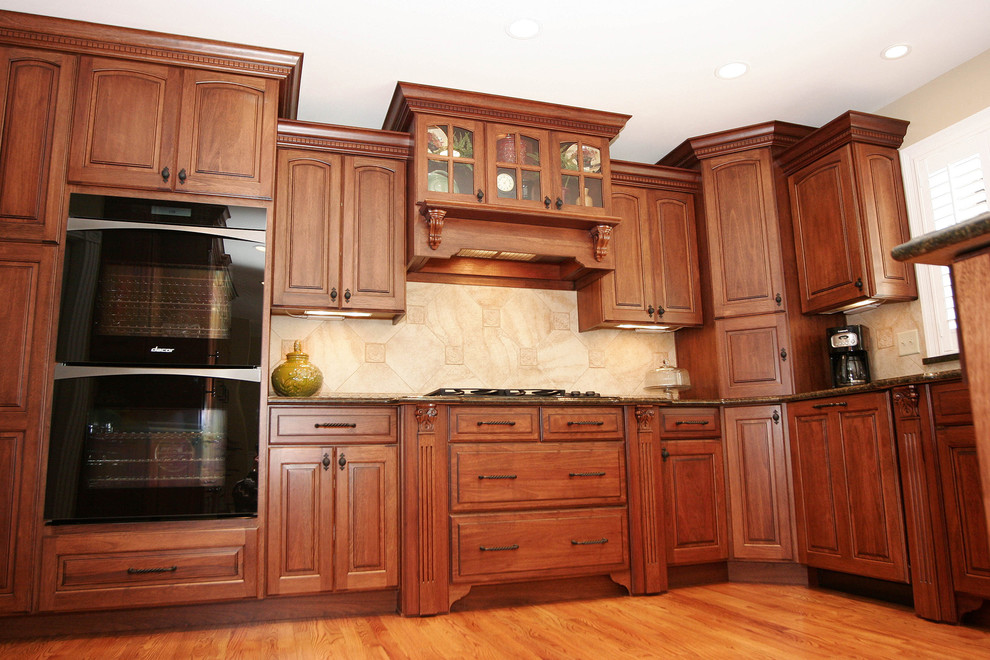 U-shaped eat-in kitchen photo in St Louis with an undermount sink, medium tone wood cabinets, granite countertops and paneled appliances