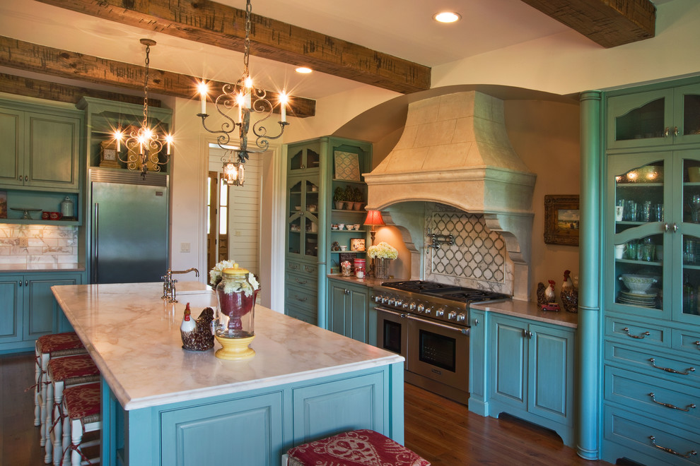 Inredning av ett klassiskt stort kök, med luckor med infälld panel, blå skåp, bänkskiva i kvarts, vitt stänkskydd, stänkskydd i keramik, rostfria vitvaror, mellanmörkt trägolv och en köksö