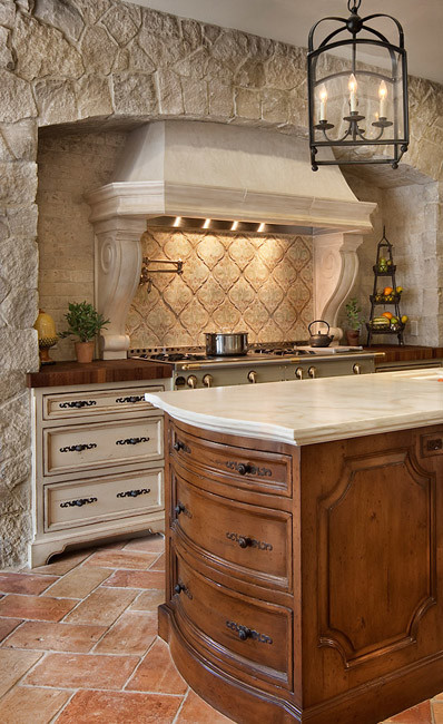 Modelo de cocina mediterránea con puertas de armario de madera oscura, encimera de mármol, salpicadero beige y salpicadero de azulejos de cerámica