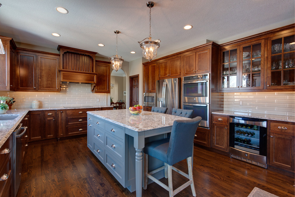 Large traditional l-shaped kitchen/diner in Minneapolis with a submerged sink, beaded cabinets, dark wood cabinets, granite worktops, green splashback, metro tiled splashback, stainless steel appliances, dark hardwood flooring and an island.