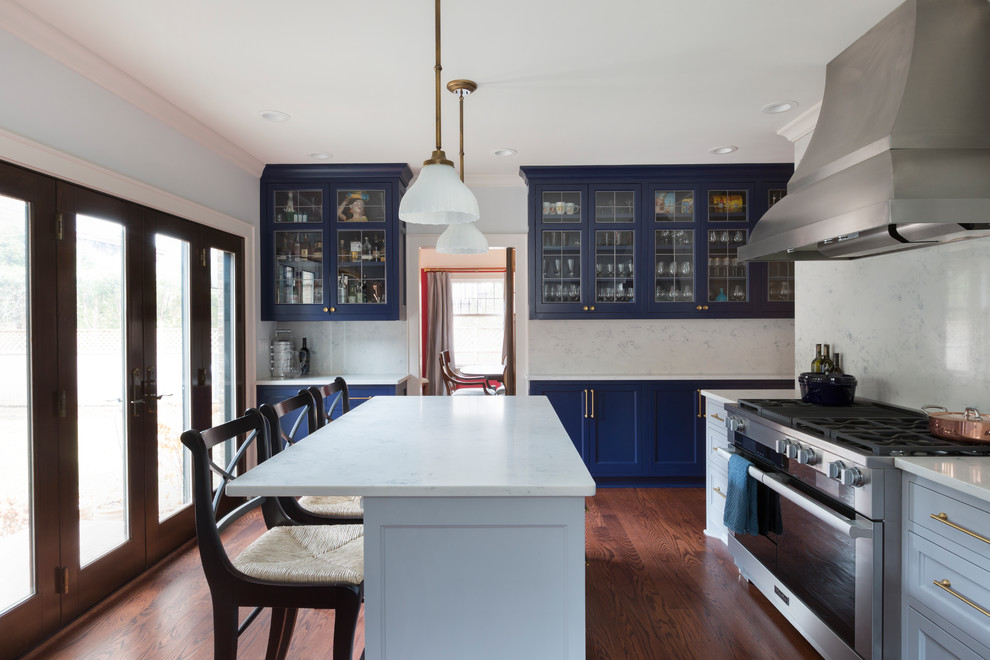 Enclosed kitchen - large traditional u-shaped light wood floor and red floor enclosed kitchen idea in Milwaukee with a farmhouse sink, shaker cabinets, blue cabinets, marble countertops, white backsplash, marble backsplash, paneled appliances and an island
