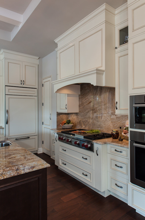 Foto på ett stort vintage kök och matrum, med en undermonterad diskho, luckor med infälld panel, vita skåp, granitbänkskiva, flerfärgad stänkskydd, stänkskydd i sten, integrerade vitvaror, mörkt trägolv och flera köksöar