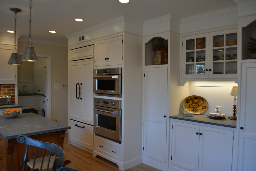 Example of a small cottage u-shaped brown floor and medium tone wood floor eat-in kitchen design in Philadelphia with white cabinets, soapstone countertops, stainless steel appliances, an island and a farmhouse sink