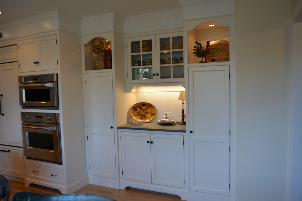 Foto de cocina de estilo de casa de campo pequeña con fregadero sobremueble, puertas de armario blancas, encimera de esteatita, suelo de madera en tonos medios, una isla y suelo marrón