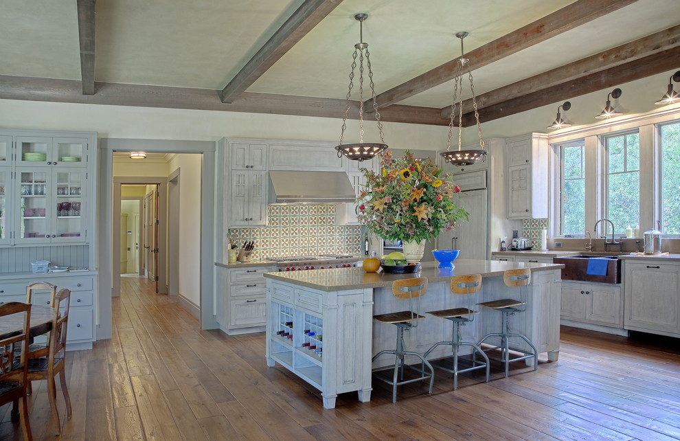 Cette image montre une cuisine encastrable traditionnelle avec un placard avec porte à panneau encastré, des portes de placard blanches et une crédence multicolore.