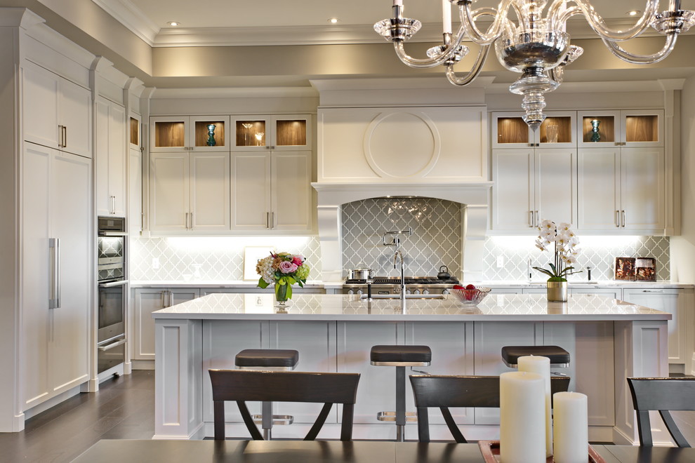 Klassische Küche in L-Form mit Schrankfronten im Shaker-Stil, weißen Schränken, Küchenrückwand in Grau, Elektrogeräten mit Frontblende und Kücheninsel in Toronto