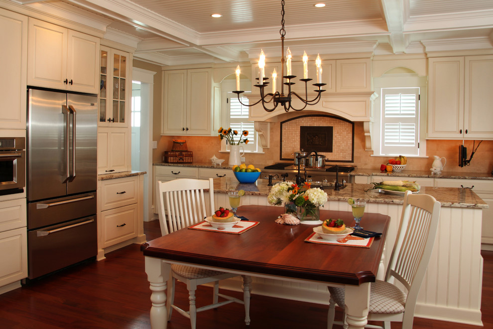 Example of a beach style eat-in kitchen design in Philadelphia with raised-panel cabinets, white cabinets, beige backsplash and stainless steel appliances