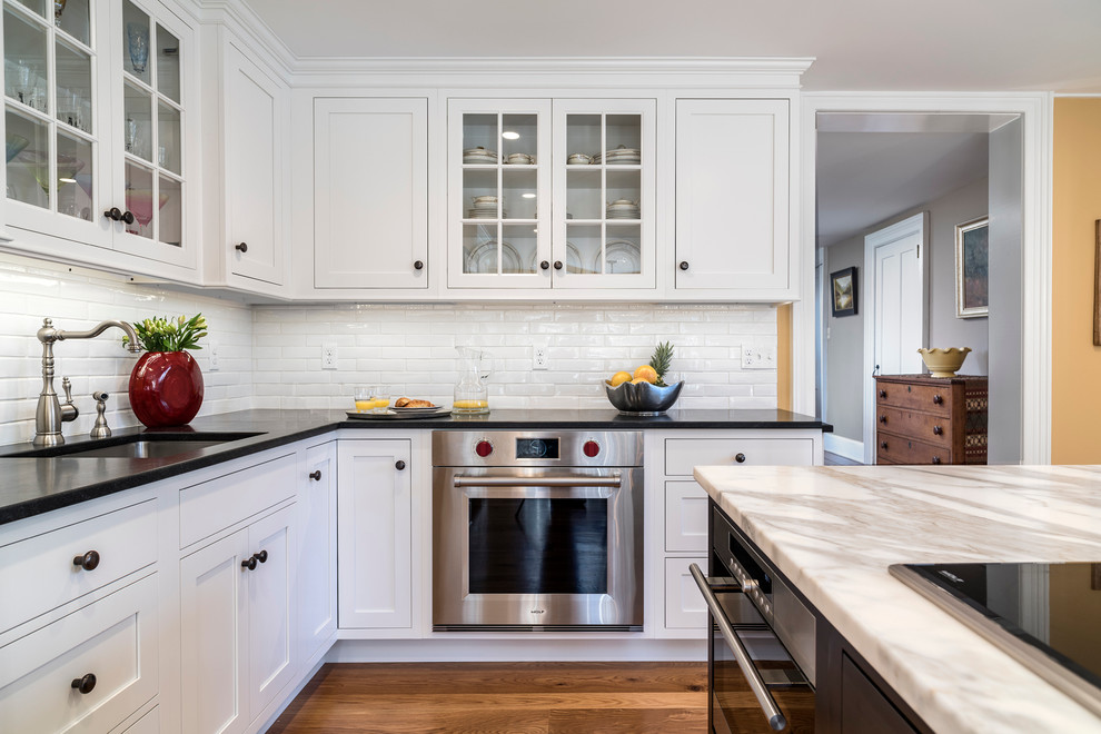 Eat-in kitchen - large traditional u-shaped light wood floor eat-in kitchen idea in Bridgeport with an undermount sink, white cabinets, granite countertops, white backsplash, subway tile backsplash, stainless steel appliances, an island and shaker cabinets