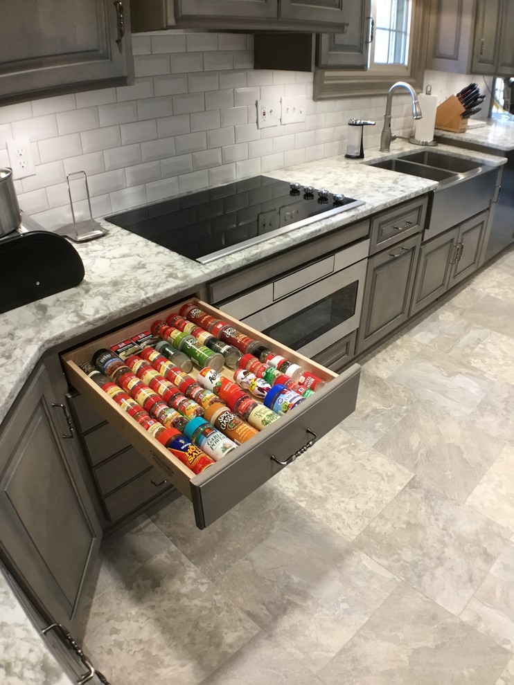 Example of a mid-sized classic vinyl floor and multicolored floor kitchen design in Cleveland with a farmhouse sink, raised-panel cabinets, gray cabinets, quartz countertops, white backsplash, subway tile backsplash and stainless steel appliances
