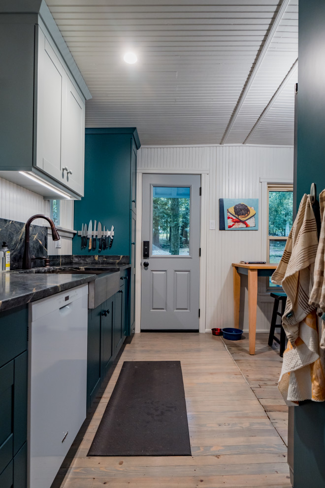 Small country galley kitchen/diner in Other with a submerged sink, shaker cabinets, green cabinets, soapstone worktops, black splashback, light hardwood flooring, no island, beige floors, black worktops and a wood ceiling.