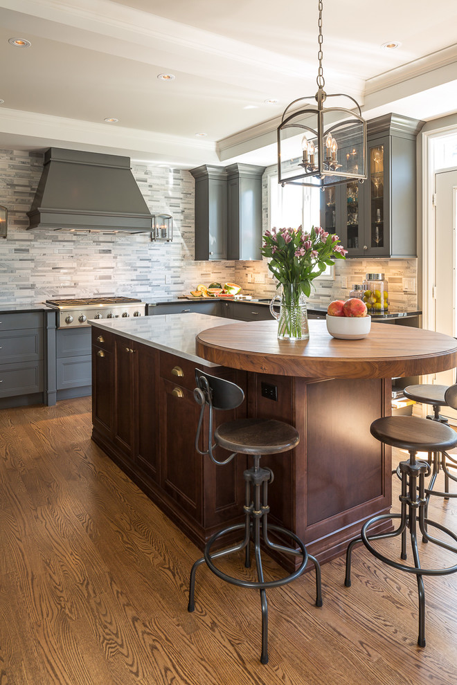 Eat-in kitchen - mid-sized traditional u-shaped medium tone wood floor eat-in kitchen idea in Ottawa with gray backsplash, stainless steel appliances and an island