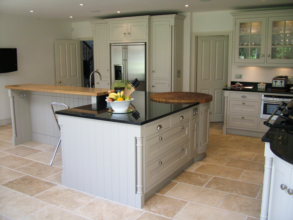 This is an example of a large classic l-shaped kitchen/diner in Buckinghamshire with a belfast sink, shaker cabinets, grey cabinets, onyx worktops, black appliances and an island.