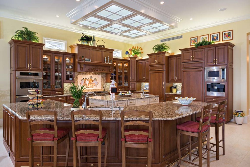 Large elegant l-shaped porcelain tile eat-in kitchen photo in Miami with an undermount sink, raised-panel cabinets, dark wood cabinets, granite countertops, multicolored backsplash, stone slab backsplash, paneled appliances and two islands