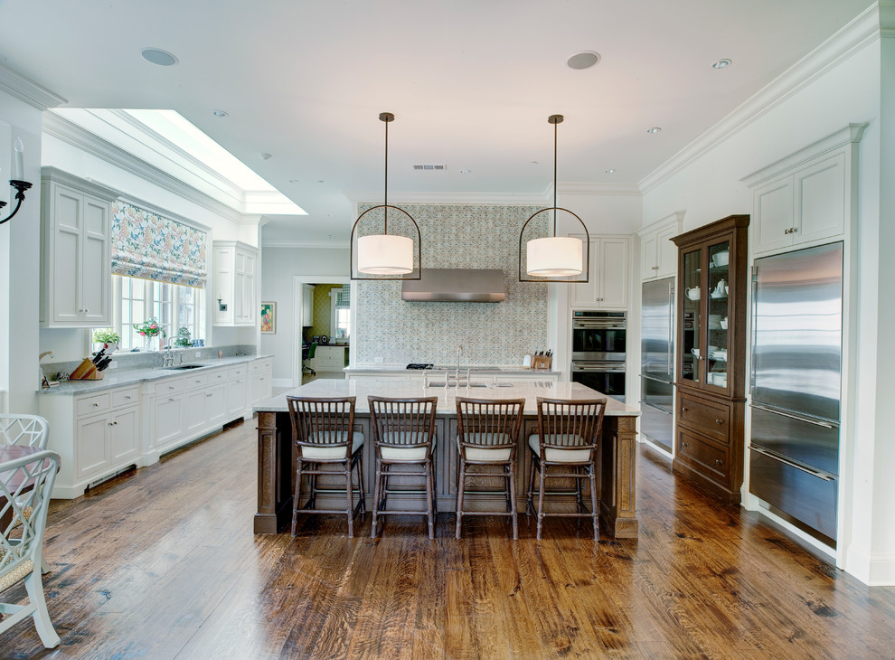 Inspiration for a large traditional kitchen in Denver with a single-bowl sink, recessed-panel cabinets, white cabinets, quartz worktops, porcelain splashback, stainless steel appliances, medium hardwood flooring and an island.